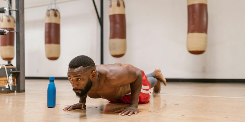 A focused man doing push-ups in a spacious, well-lit room.