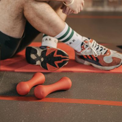 Close-up of athletic shoes on a yoga mat before a workout.