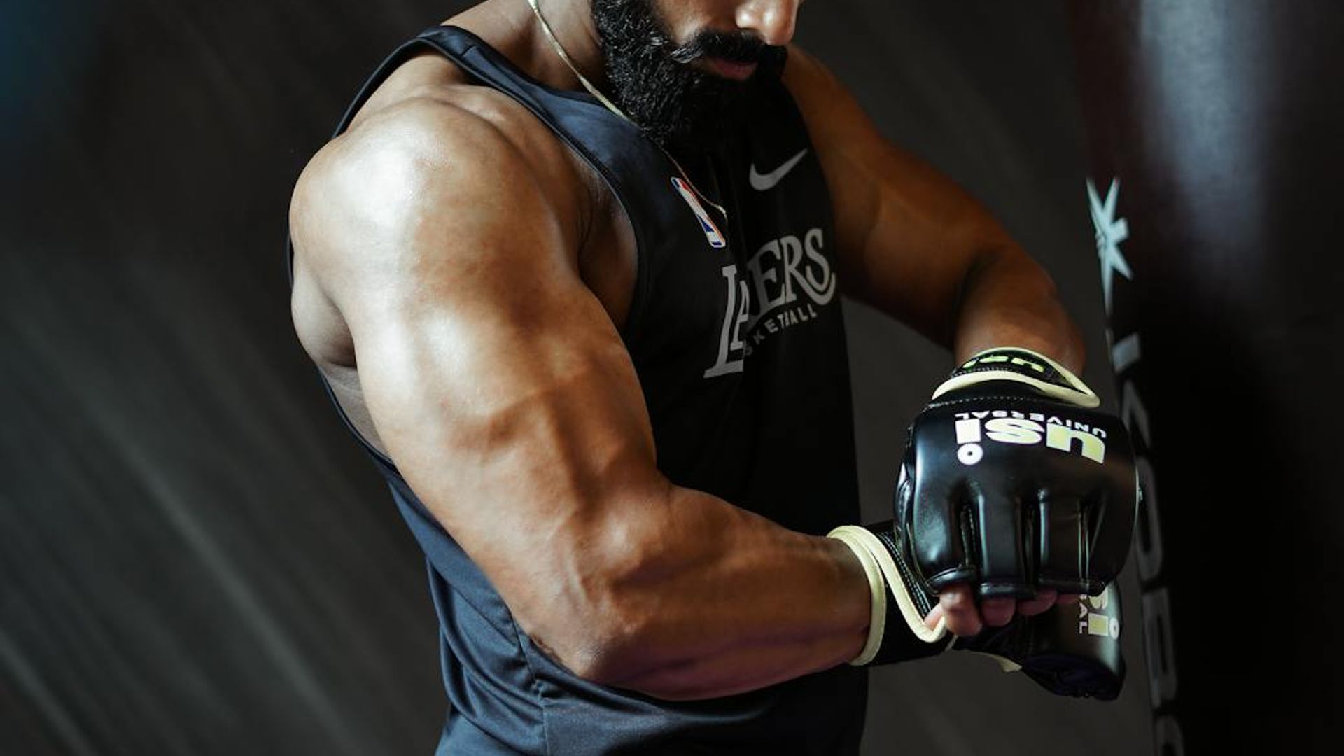 Man in a focused stance in a minimalist gym setting.